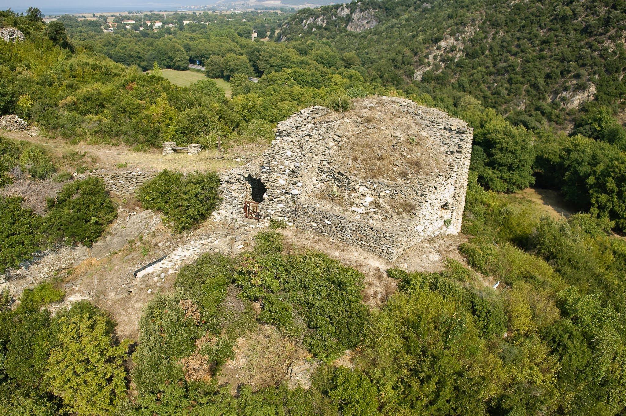 An oblique aerial photograph of the stone ruins at the Castle of Rentina, Greece, showing a historical structure built of rough masonry on a vegetated hillside.